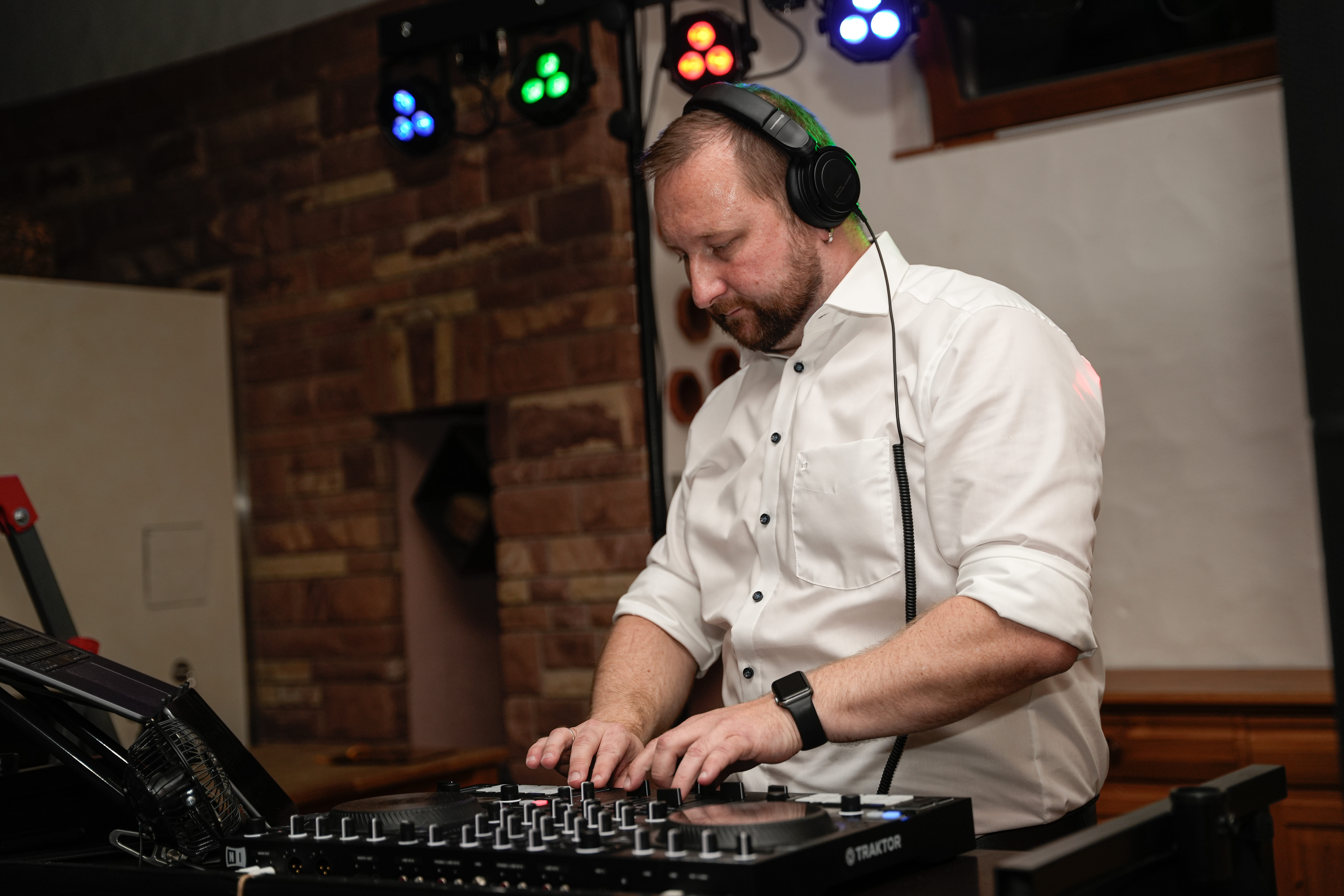 Hochzeits-DJ Tony Lötzke konzentriert am DJ-Pult mit Kopfhörern und RANE Controller